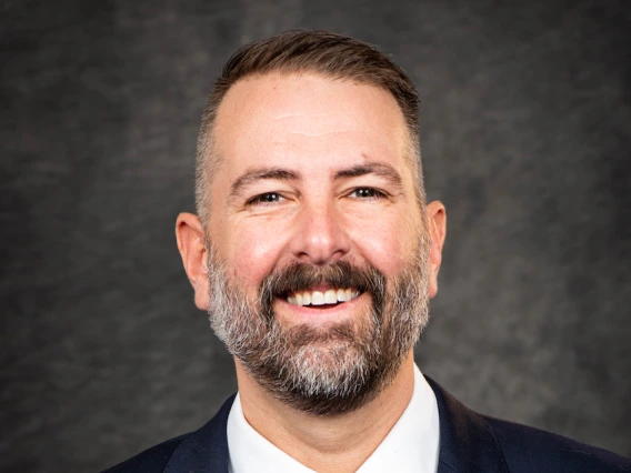 Caleb Simmons Headshot with blue suit, white shirt, and red tie