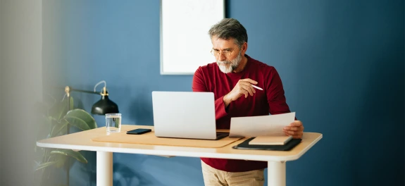 Middle aged person working at a standing desk