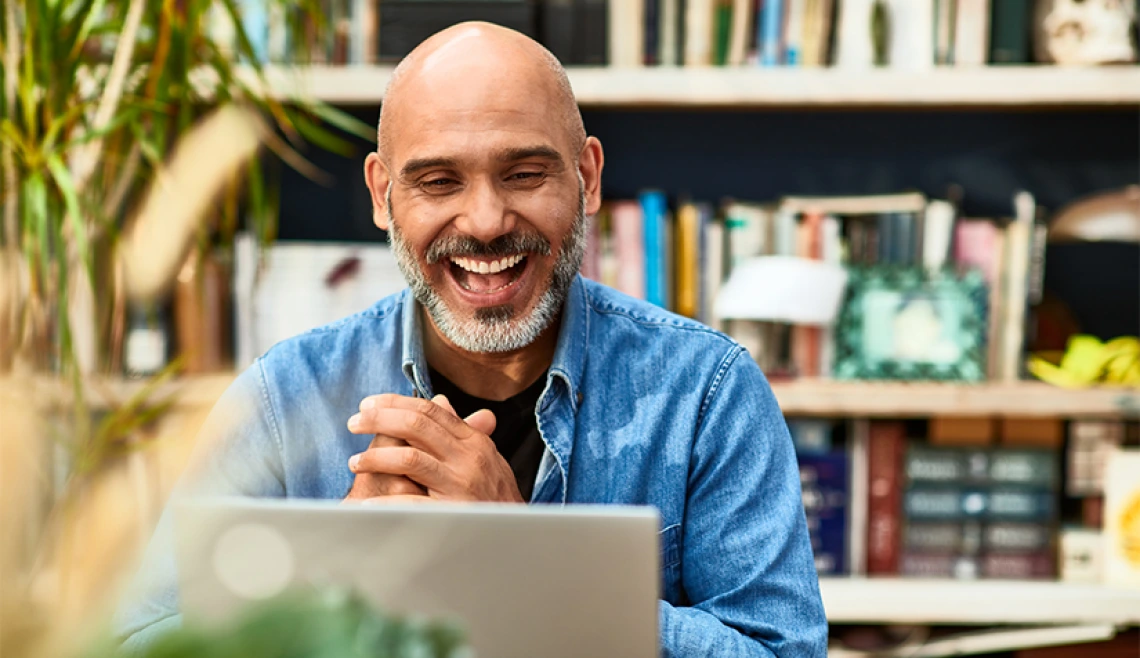 Person smiling and working on laptop
