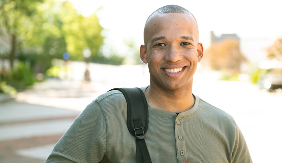 Man dressed in green smiling outside for portrait photo