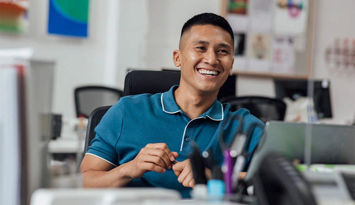 Student smiling while sitting at work desk