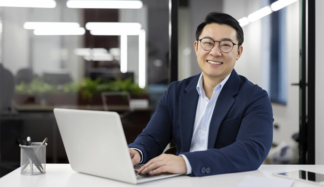 Person smiling and sitting at their laptop