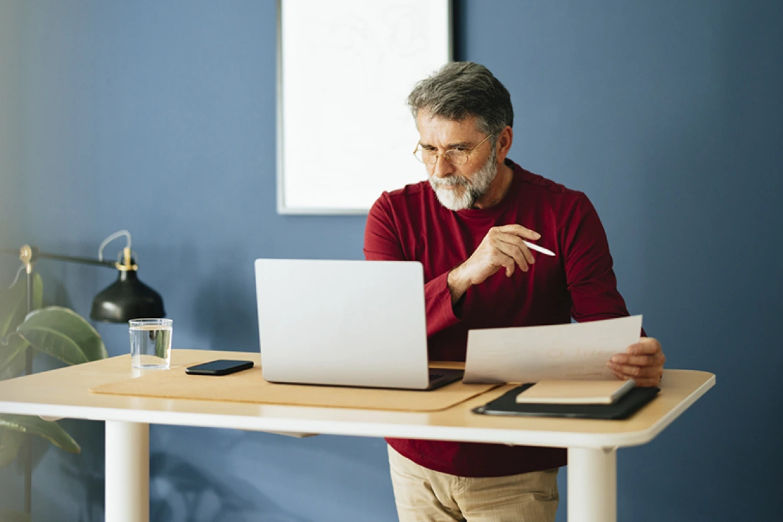 Middle aged person working at a standing desk