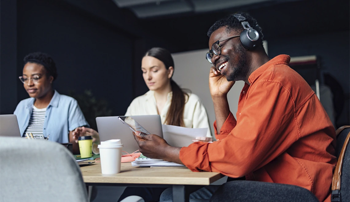 Student smiling while sitting at desk with other students