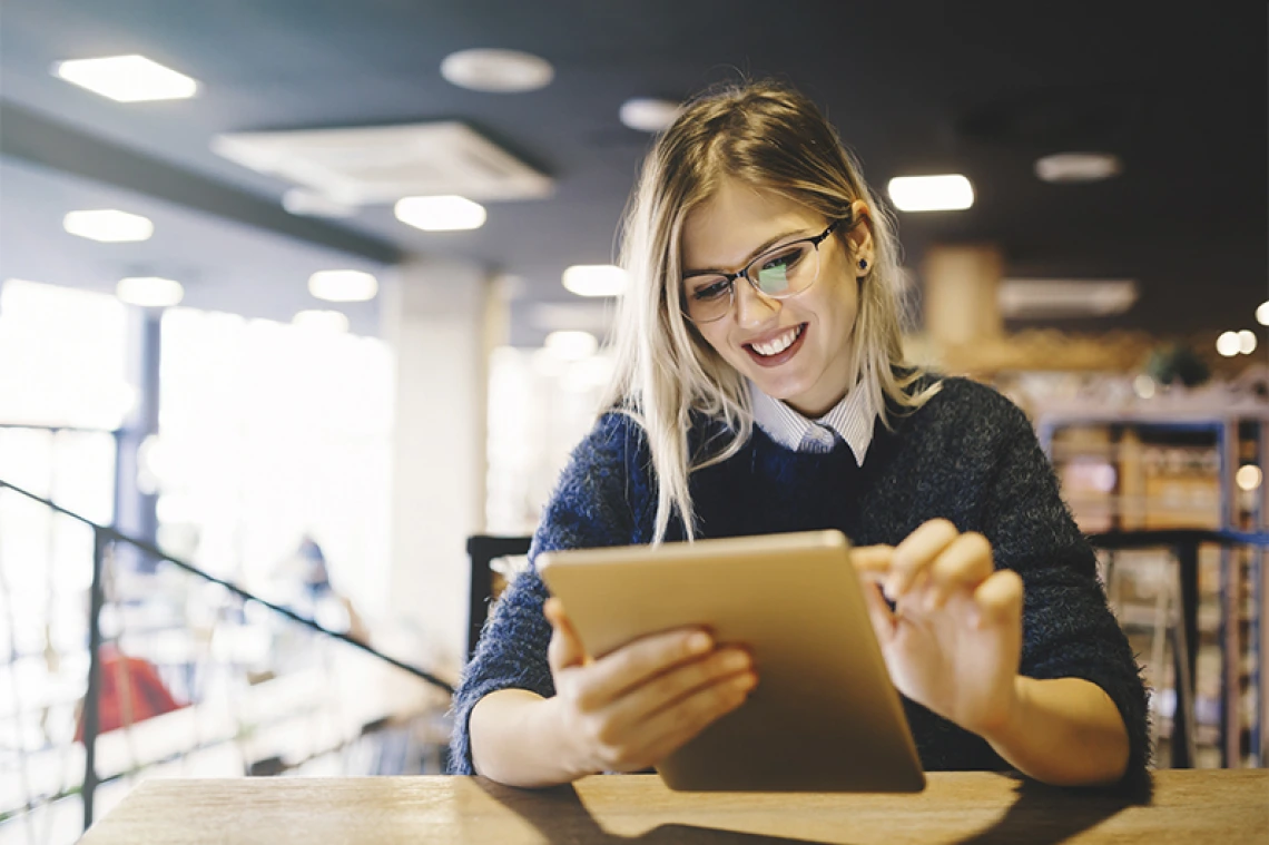 Student smiling and working on tablet