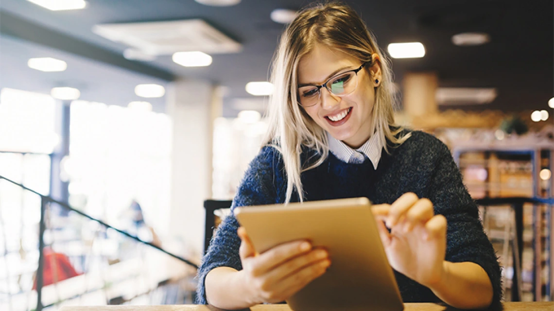 Student smiling and working on tablet