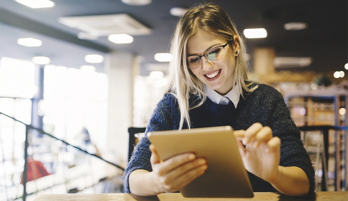 Student smiling and working on tablet