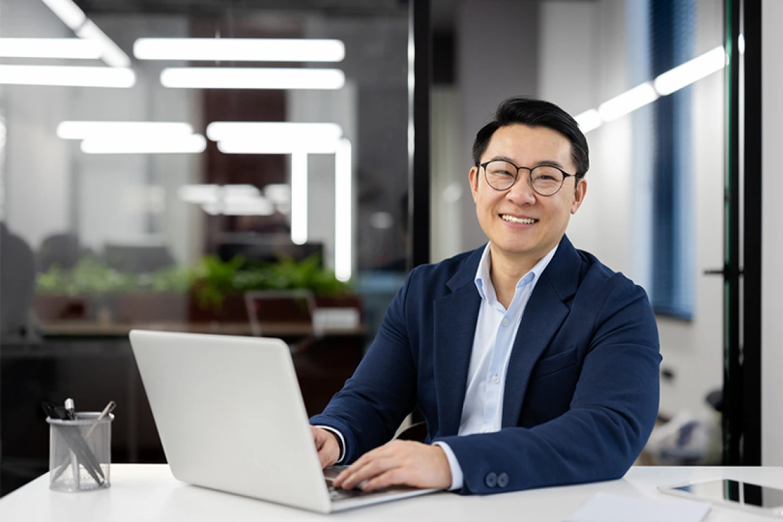 Smiling businessperson working at laptop