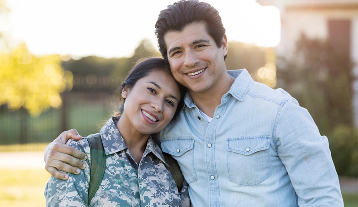 Military member smiling and posing for photo with man