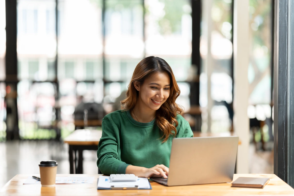 Asian woman working with laptop in her office.