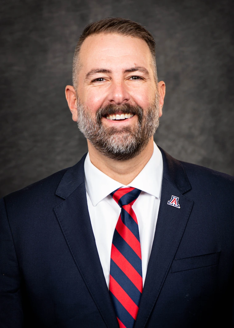 Caleb Simmons Headshot with blue suit, white shirt, and red tie